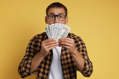 Photo of Man with dollar banknotes on yellow background