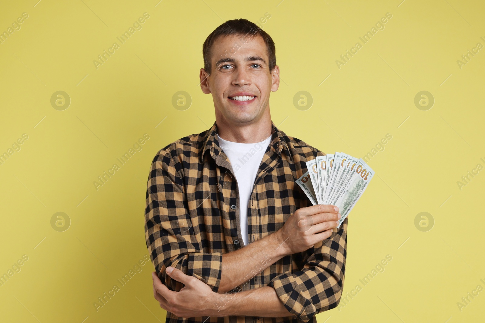 Photo of Happy man with money on yellow background