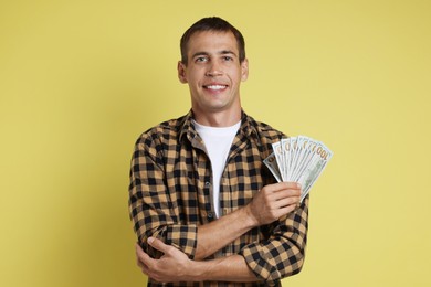 Photo of Happy man with money on yellow background