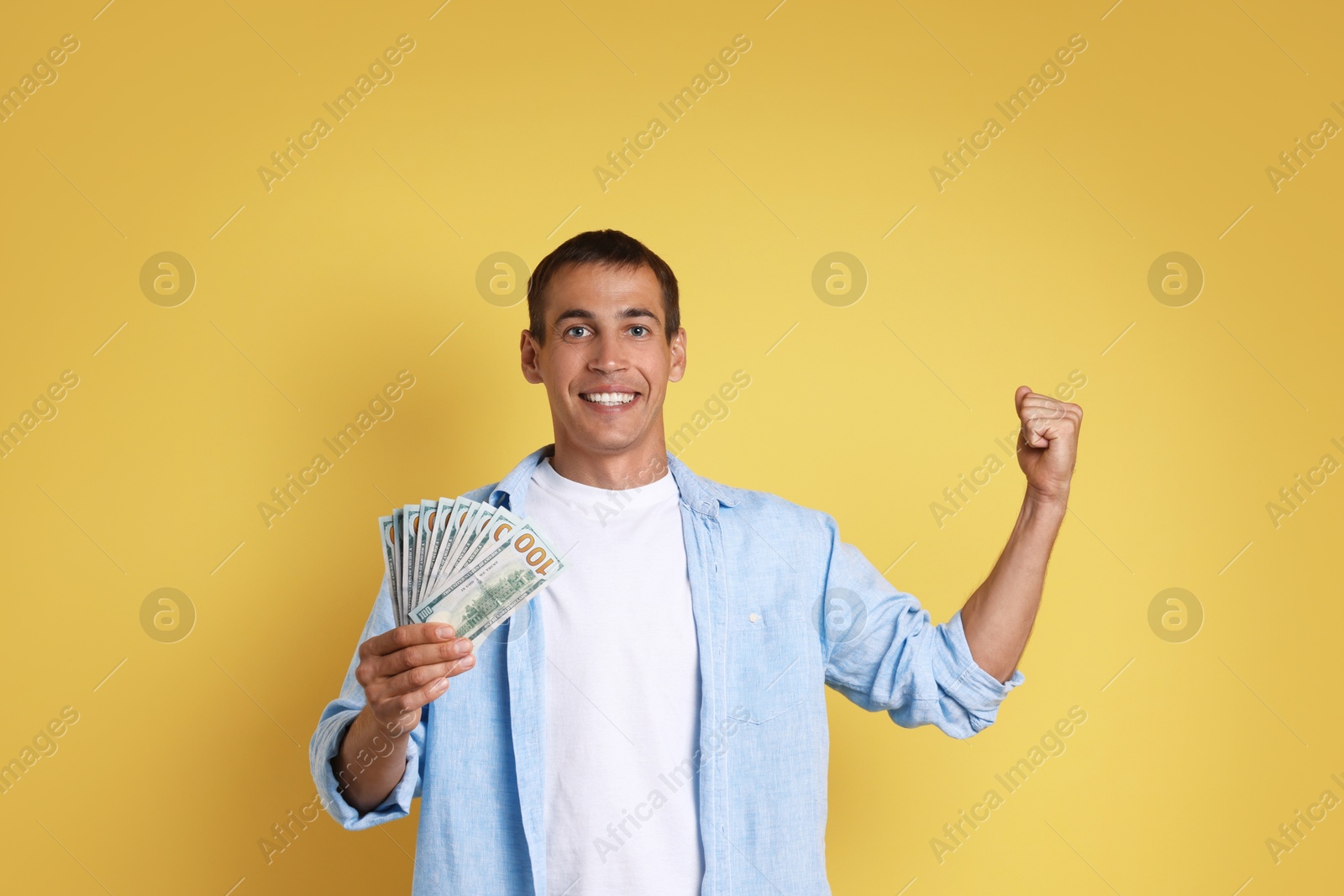 Photo of Happy man with money on yellow background