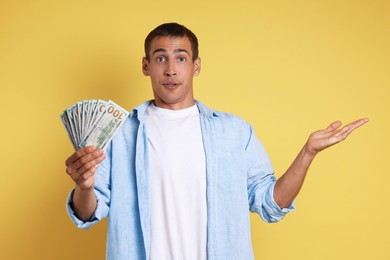 Man with dollar banknotes on yellow background