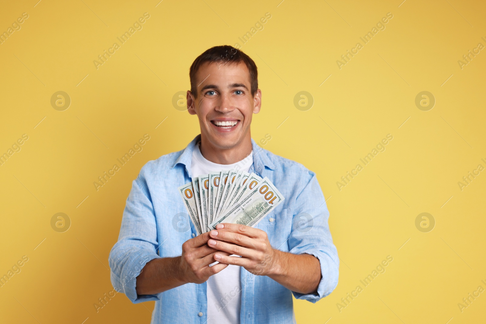 Photo of Happy man with money on yellow background