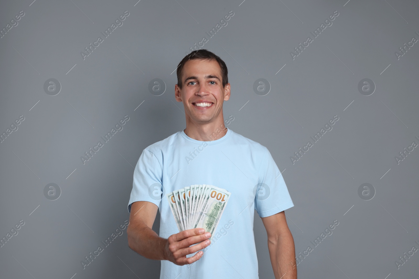 Photo of Happy man with money on grey background