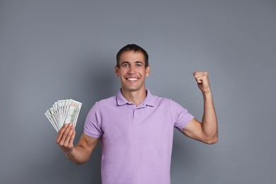 Photo of Happy man with money on grey background