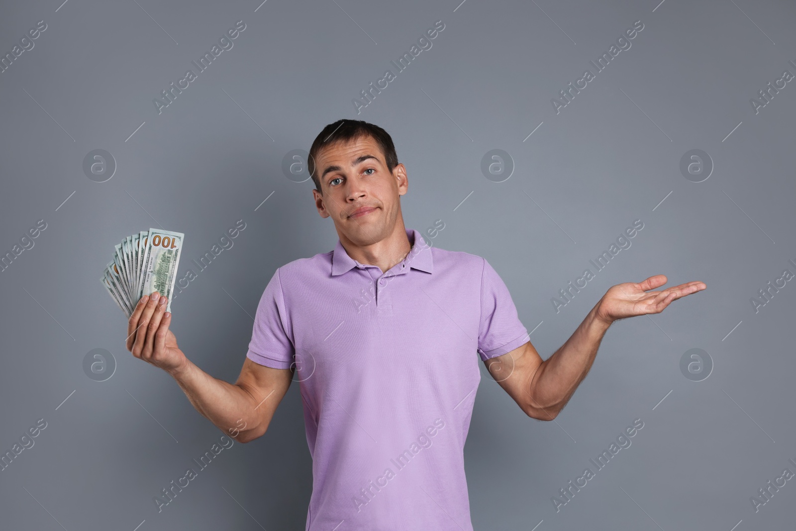 Photo of Man with dollar banknotes on grey background