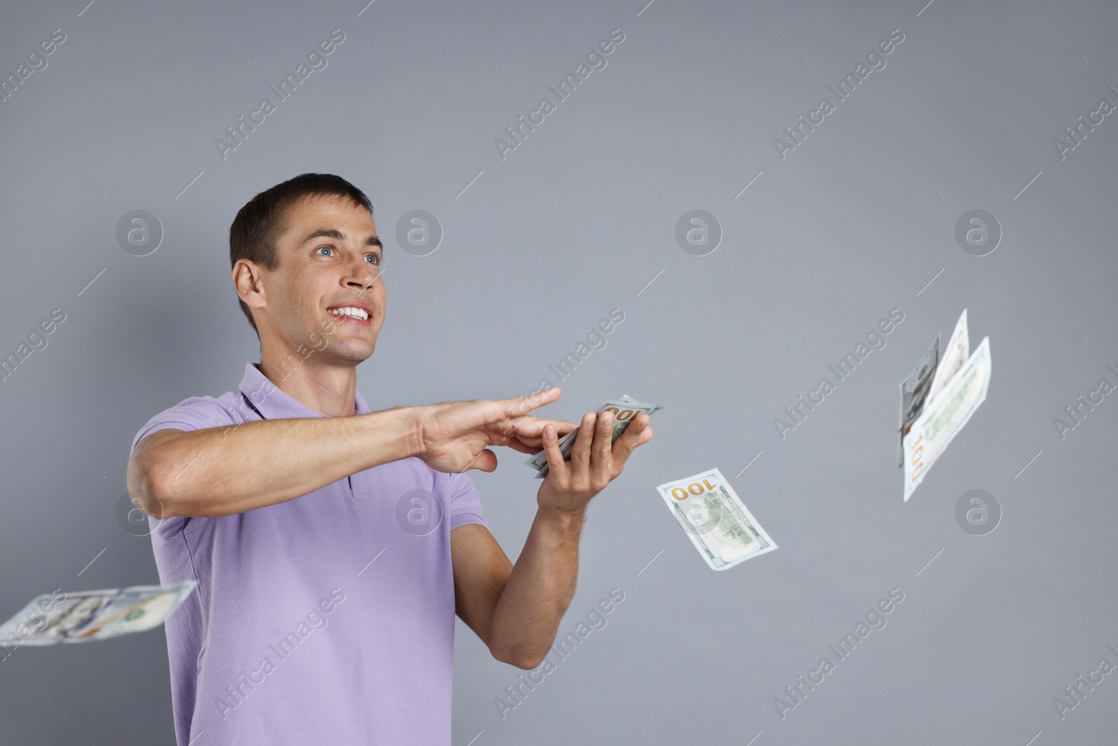 Photo of Happy man throwing money on grey background