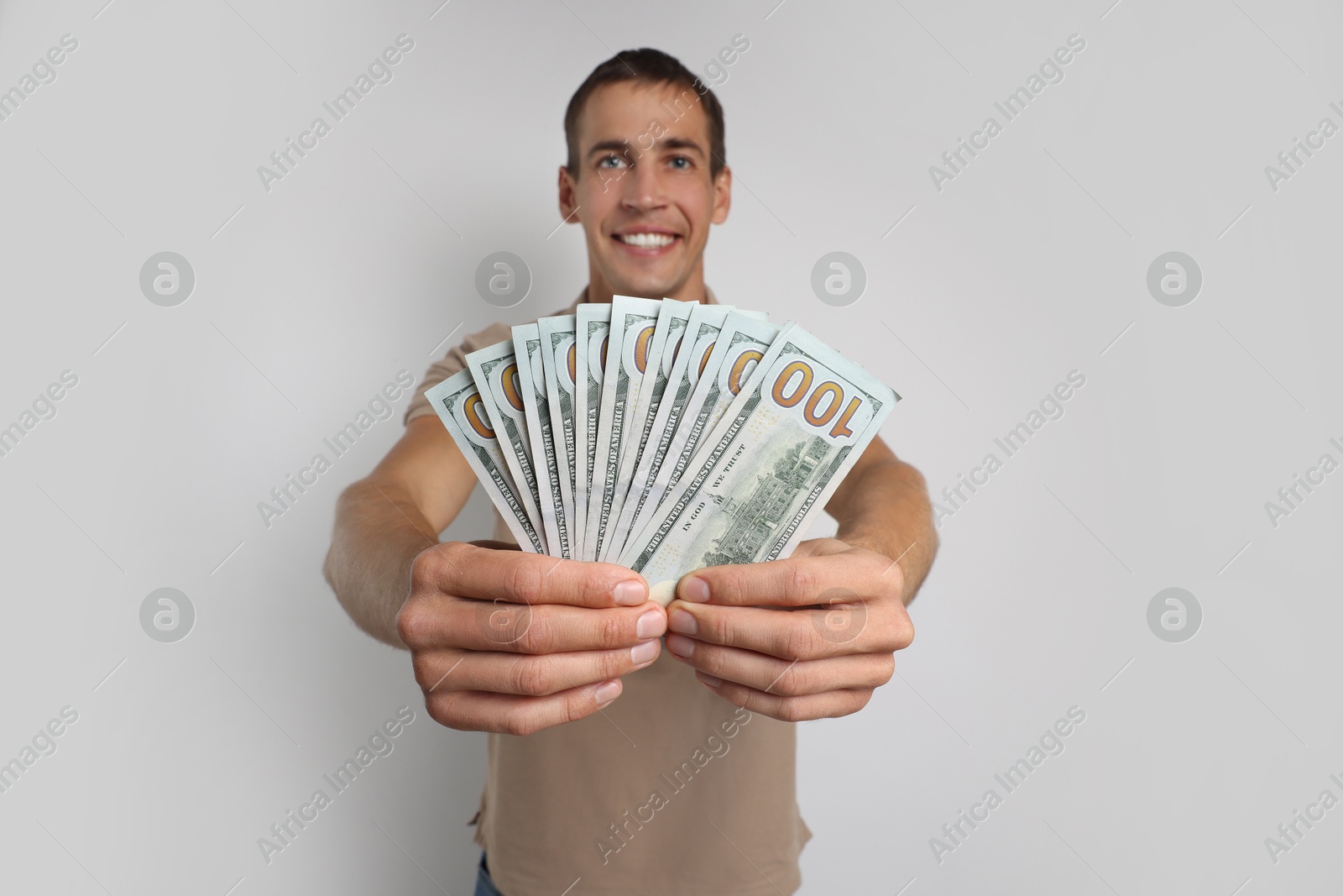 Photo of Man with dollar banknotes on white background, selective focus