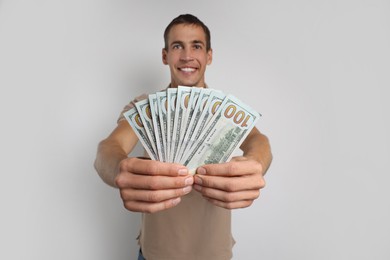 Man with dollar banknotes on white background, selective focus