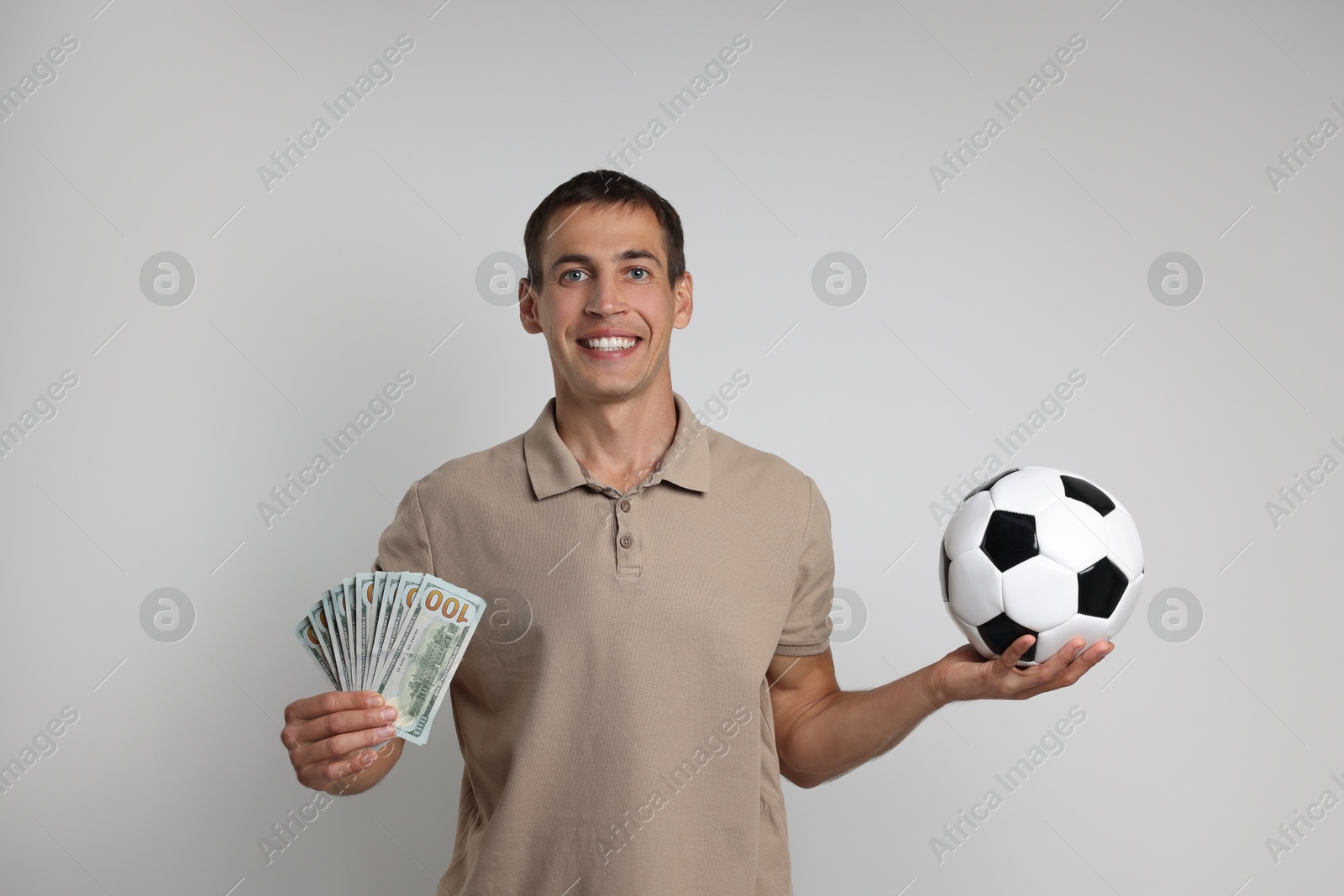 Photo of Happy man with money and soccer ball on white background