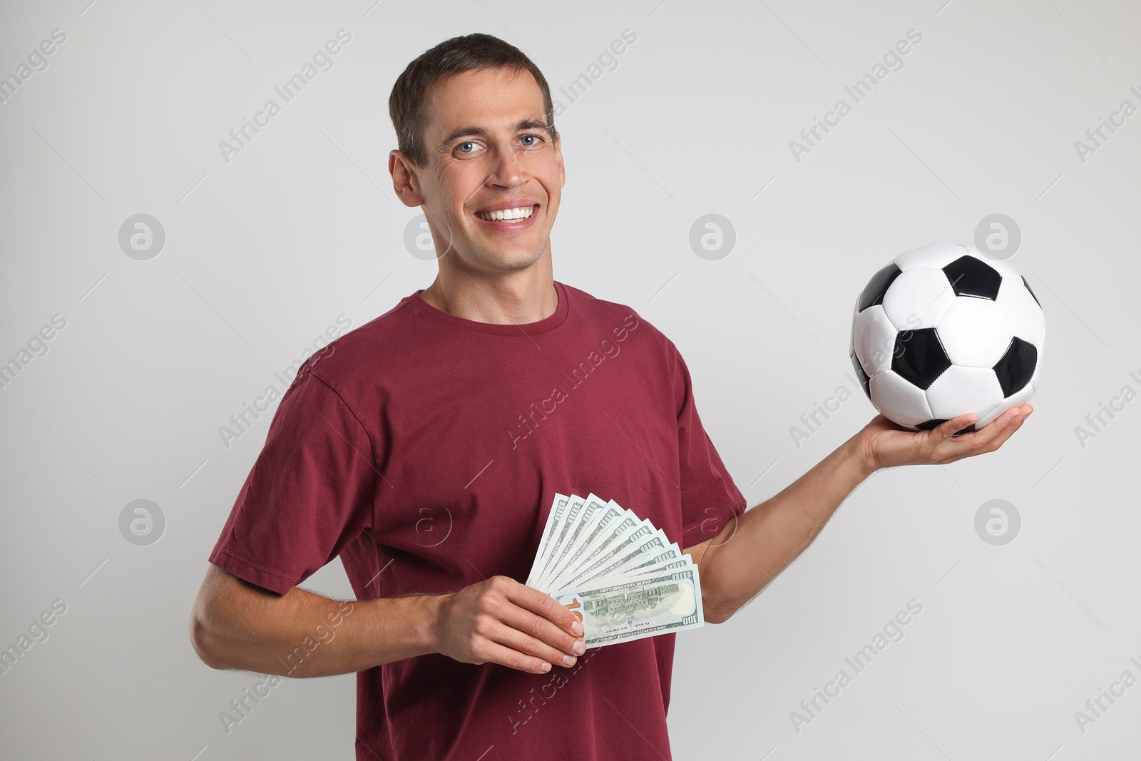 Photo of Happy man with money and soccer ball on white background