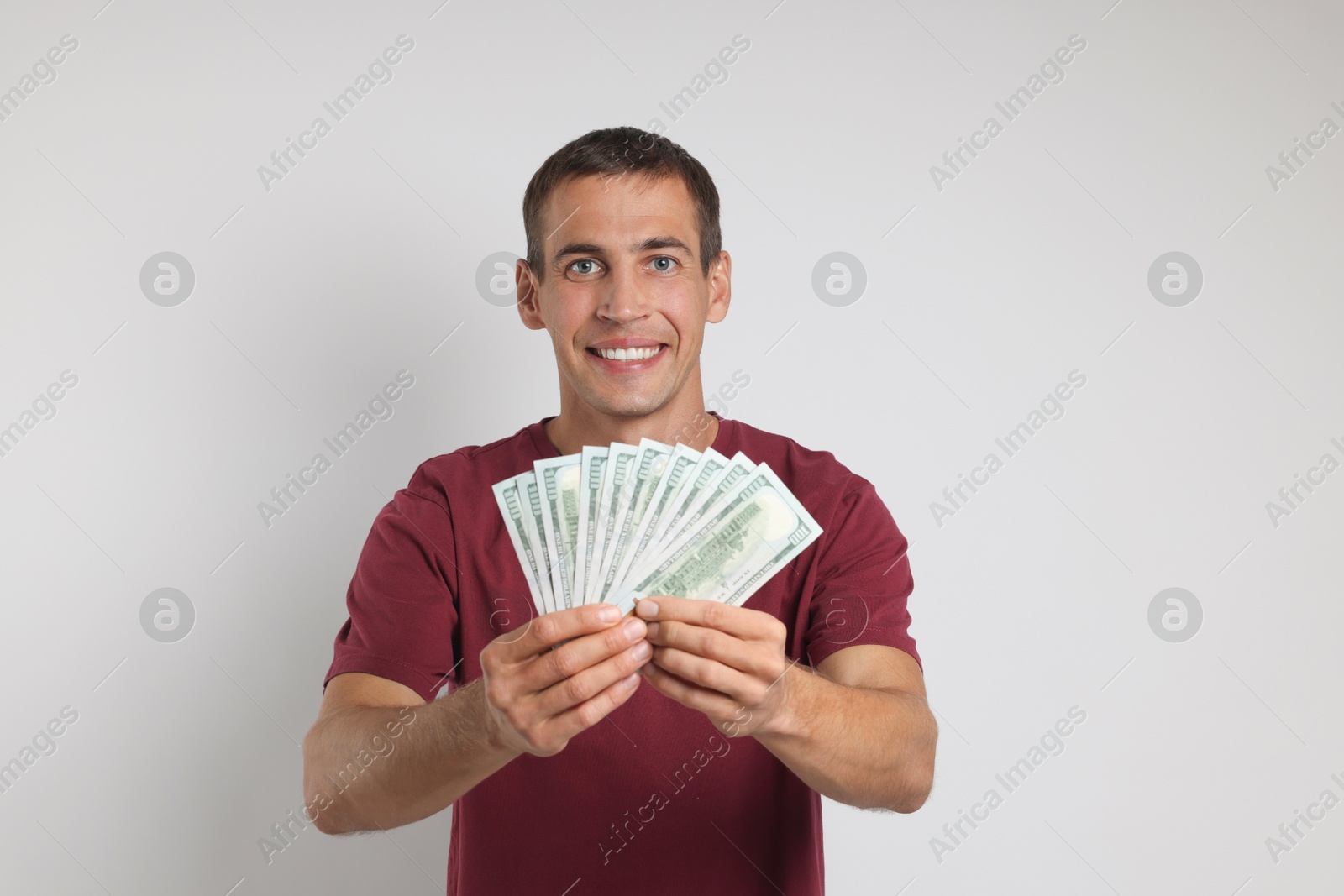 Photo of Happy man with money on white background