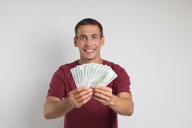 Happy man with money on white background