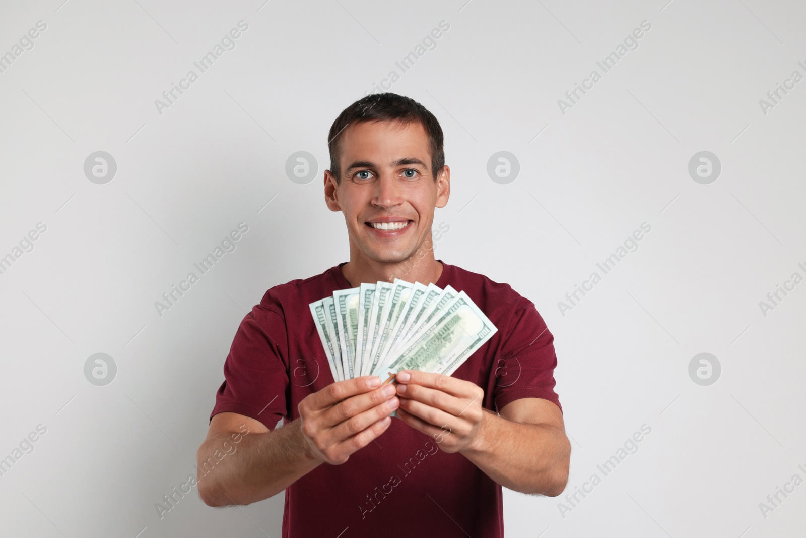 Photo of Happy man with money on white background