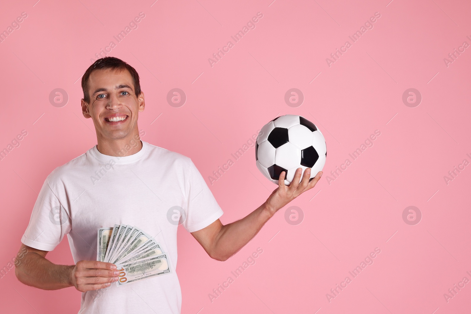 Photo of Happy man with money and soccer ball on pink background