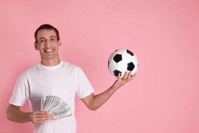 Happy man with money and soccer ball on pink background