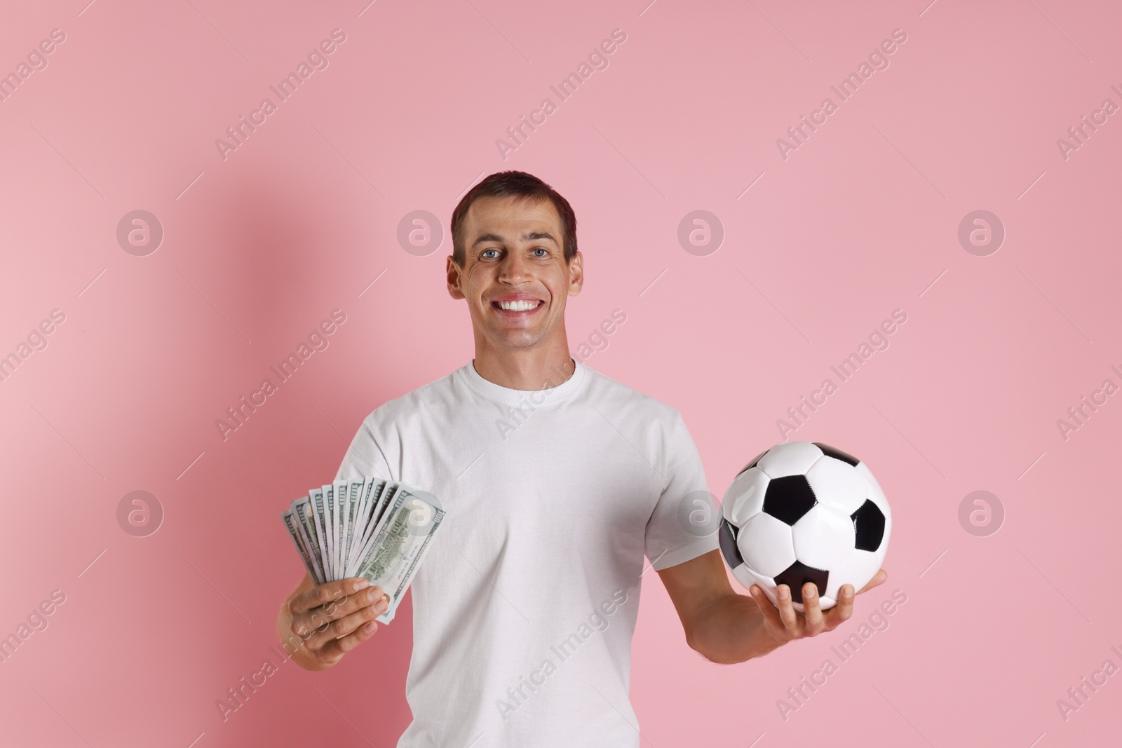 Photo of Happy man with money and soccer ball on pink background