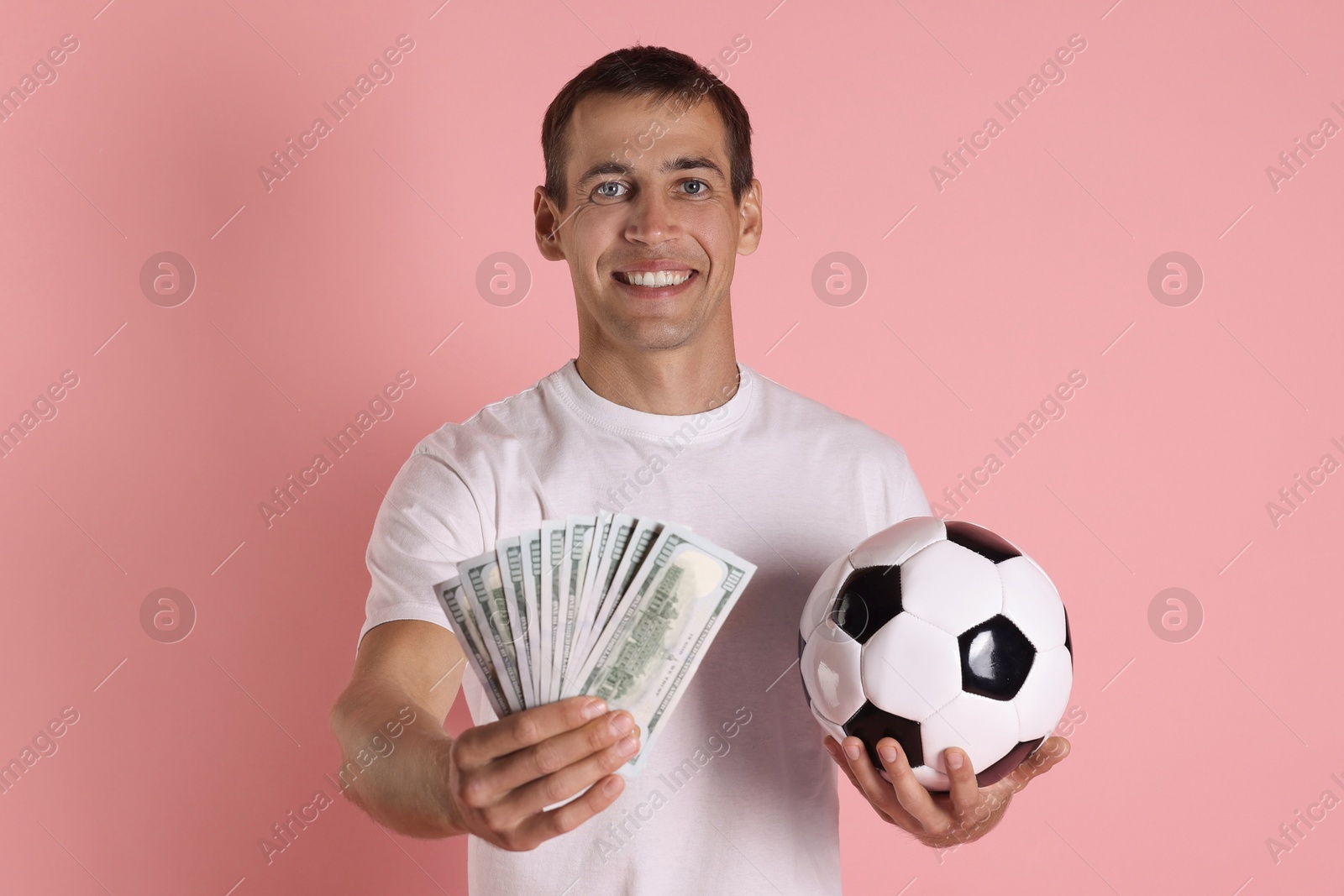 Photo of Happy man with money and soccer ball on pink background