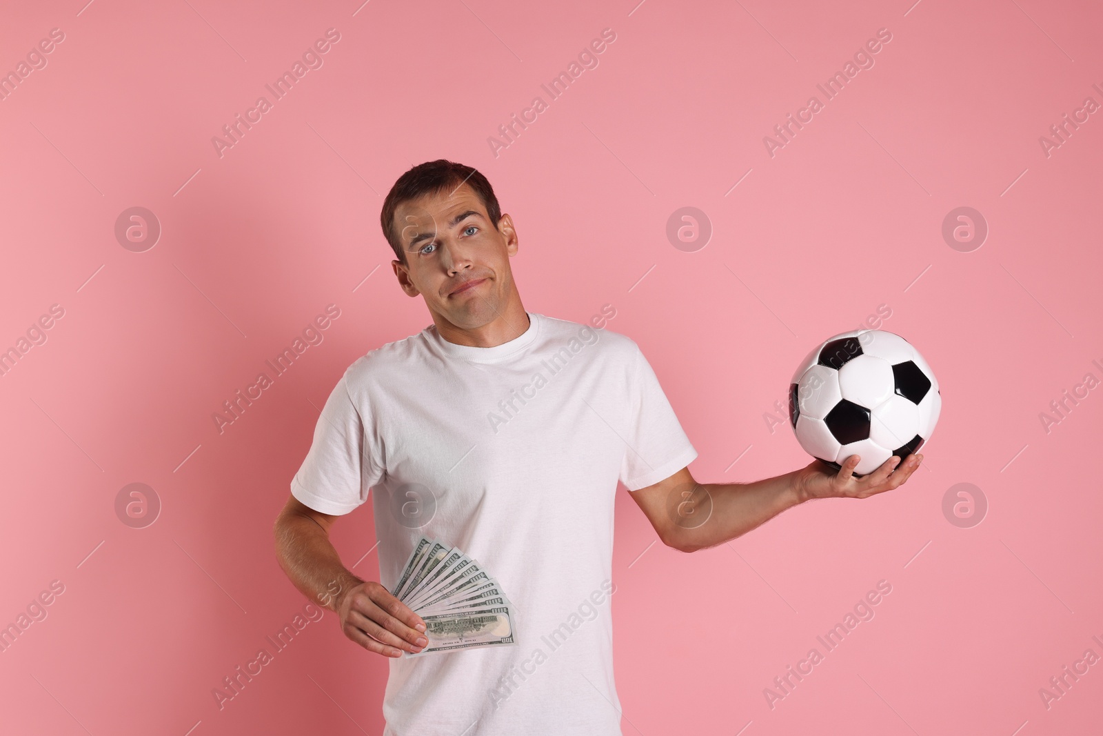 Photo of Man with money and soccer ball on pink background