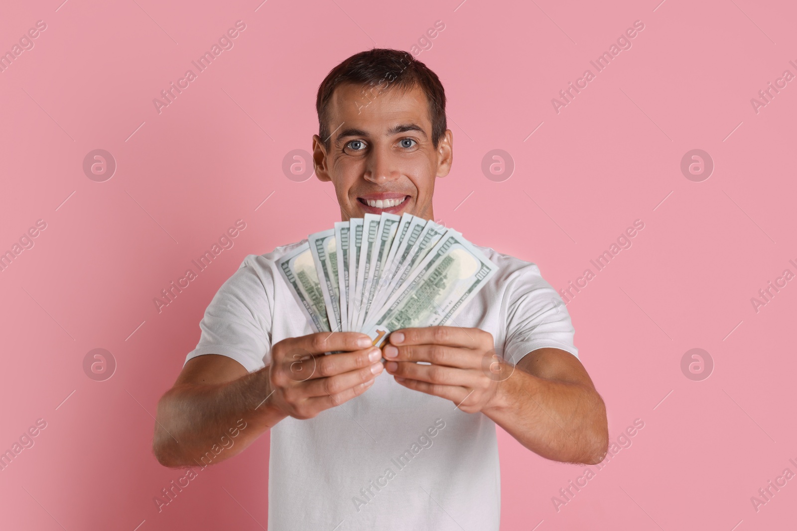 Photo of Man with dollar banknotes on pink background