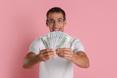 Man with dollar banknotes on pink background