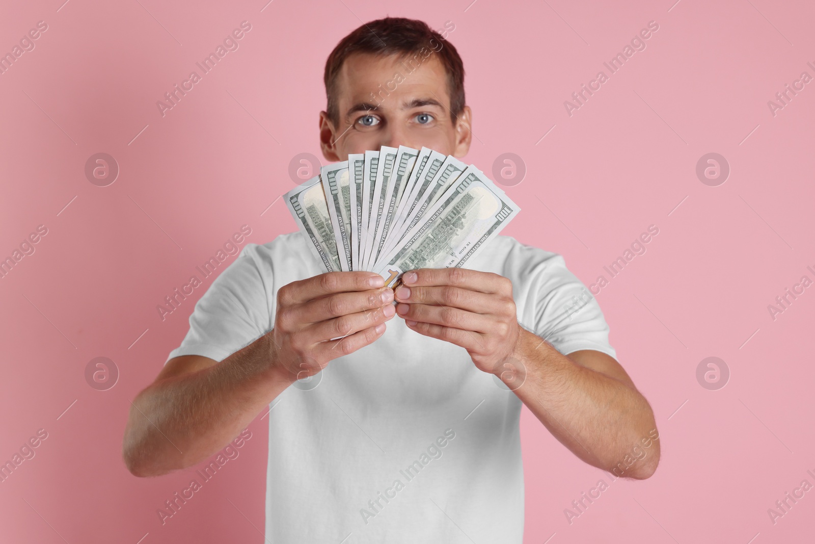 Photo of Man with dollar banknotes on pink background