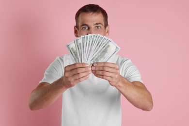 Photo of Man with dollar banknotes on pink background