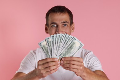 Photo of Man with dollar banknotes on pink background