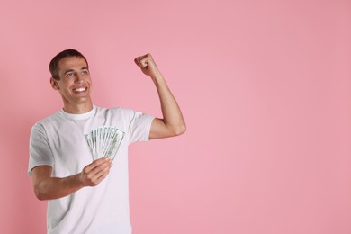 Photo of Happy man with money on pink background, space for text