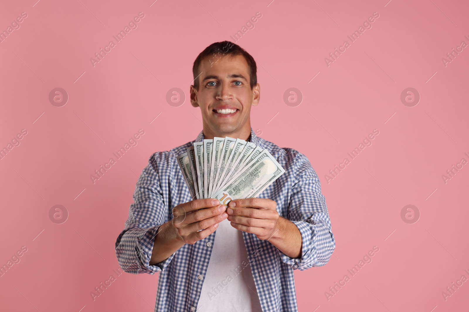 Photo of Happy man with money on pink background