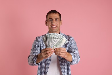 Happy man with money on pink background