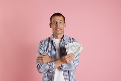 Happy man with money on pink background