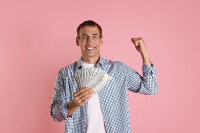 Happy man with money on pink background