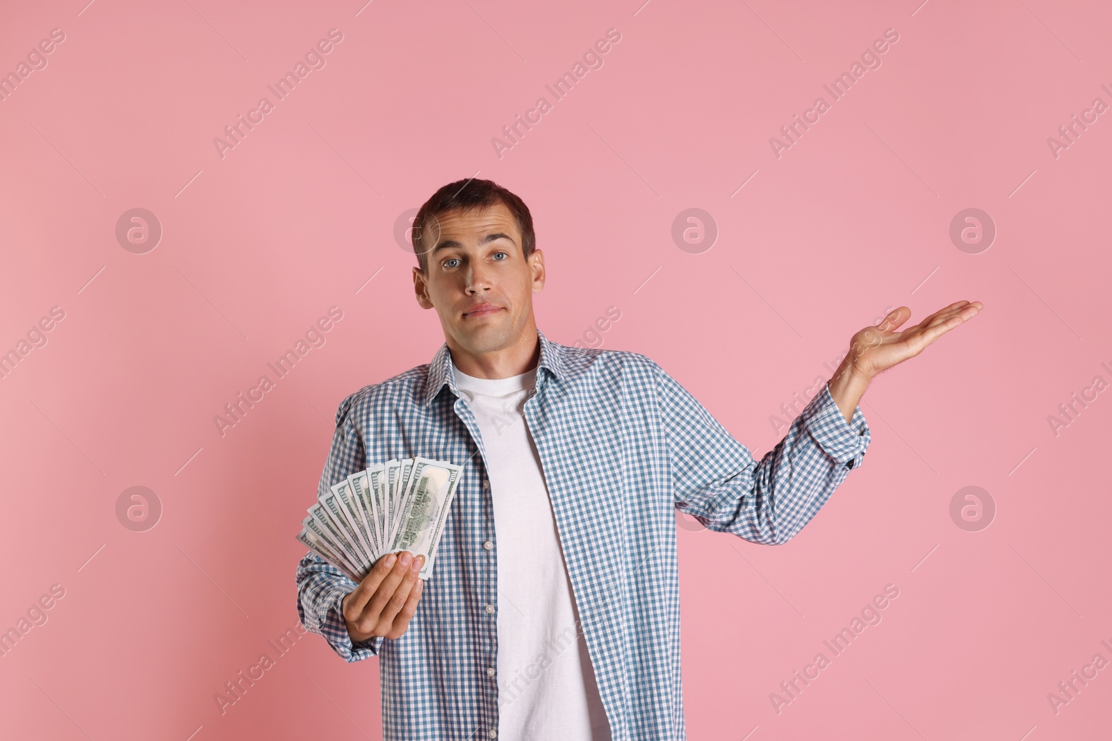 Photo of Man with dollar banknotes on pink background