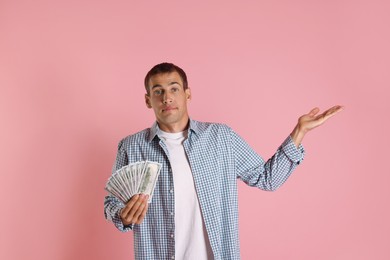 Man with dollar banknotes on pink background