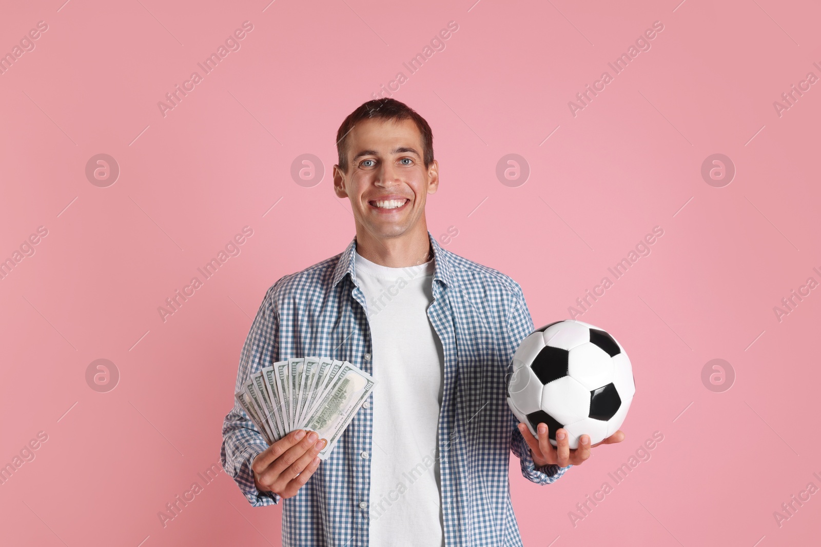 Photo of Happy man with money and soccer ball on pink background