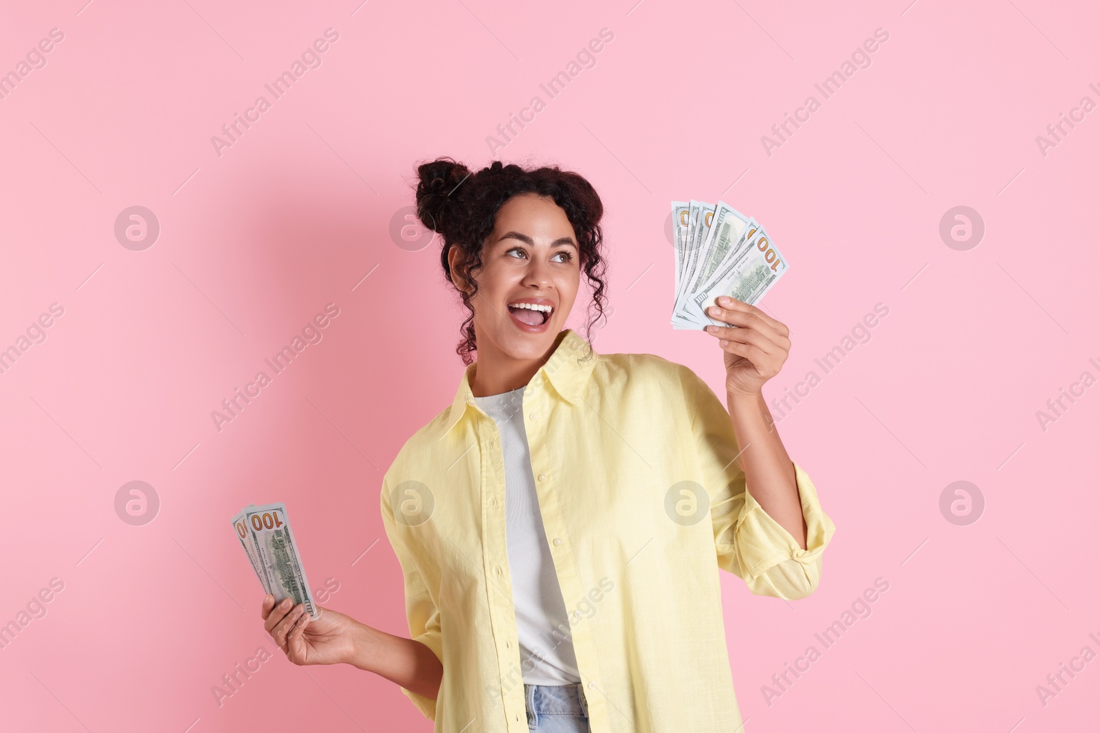 Photo of Happy woman with dollar banknotes on pink background