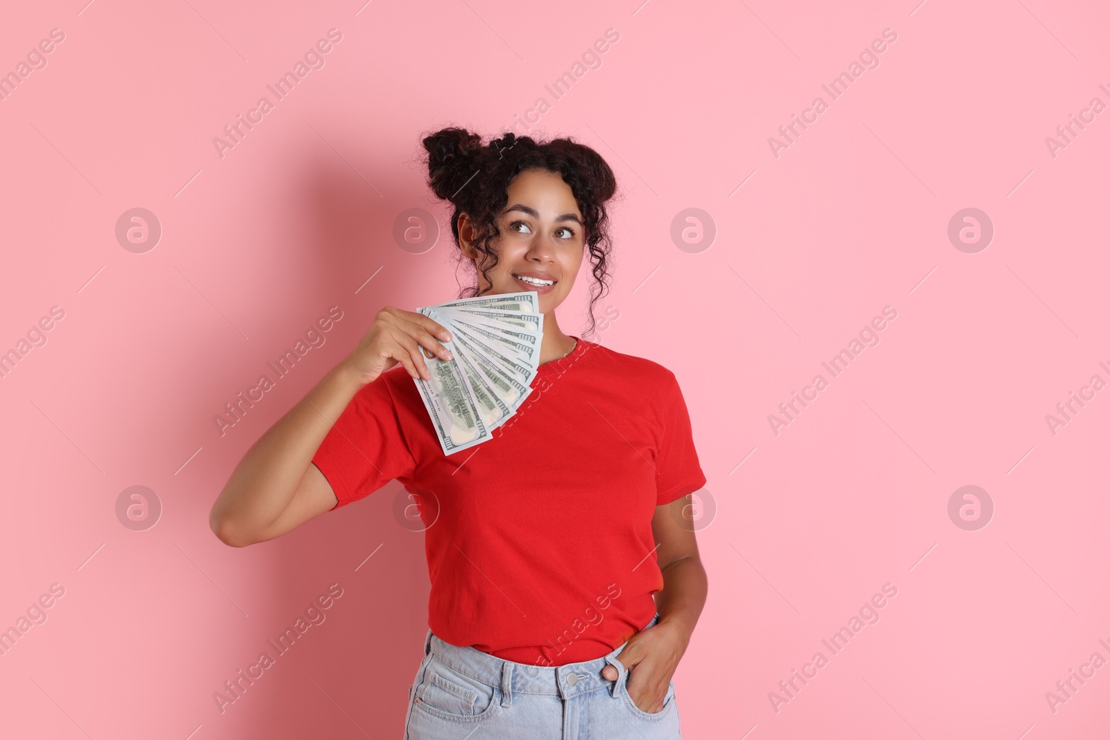 Photo of Happy woman with dollar banknotes on pink background