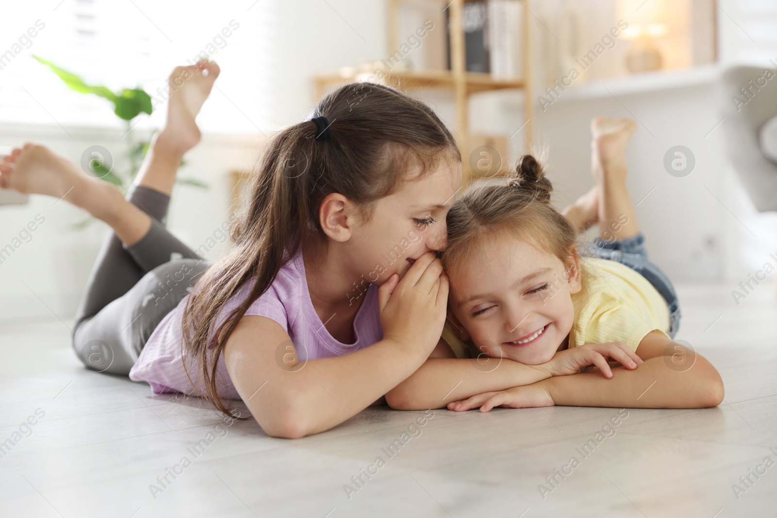 Photo of Cute little sisters spending time together at home