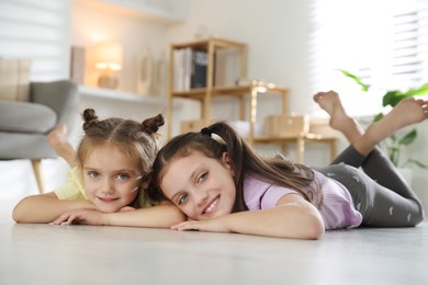 Photo of Cute little sisters spending time together at home