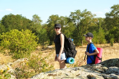 Mother and son travelling outdoors on sunny day