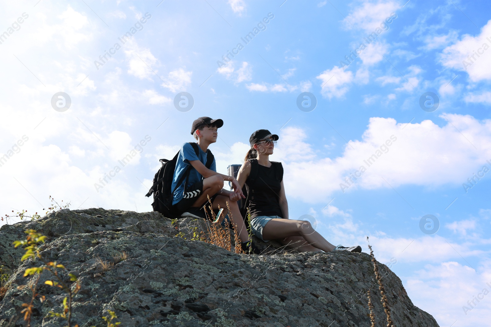 Photo of Mother and son enjoying picturesque landscape on stone