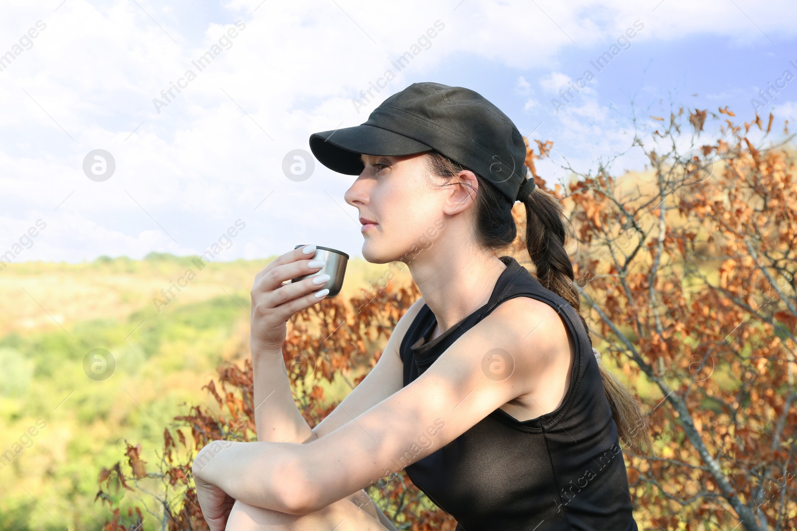 Photo of Beautiful woman drinking tea near tree outdoors