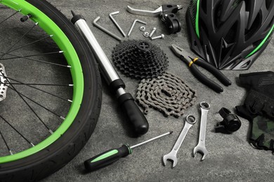 Parts of bicycle and tools on grey background, closeup