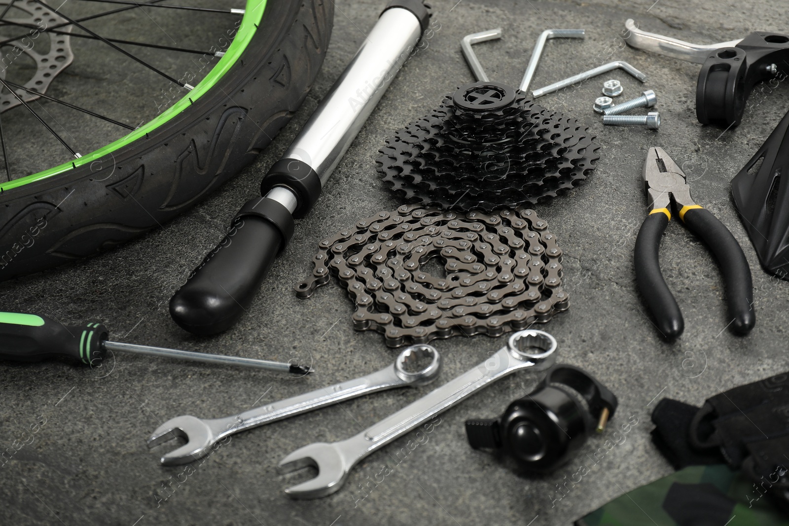 Photo of Parts of bicycle and tools on grey background, closeup