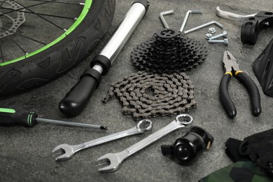 Parts of bicycle and tools on grey background, closeup