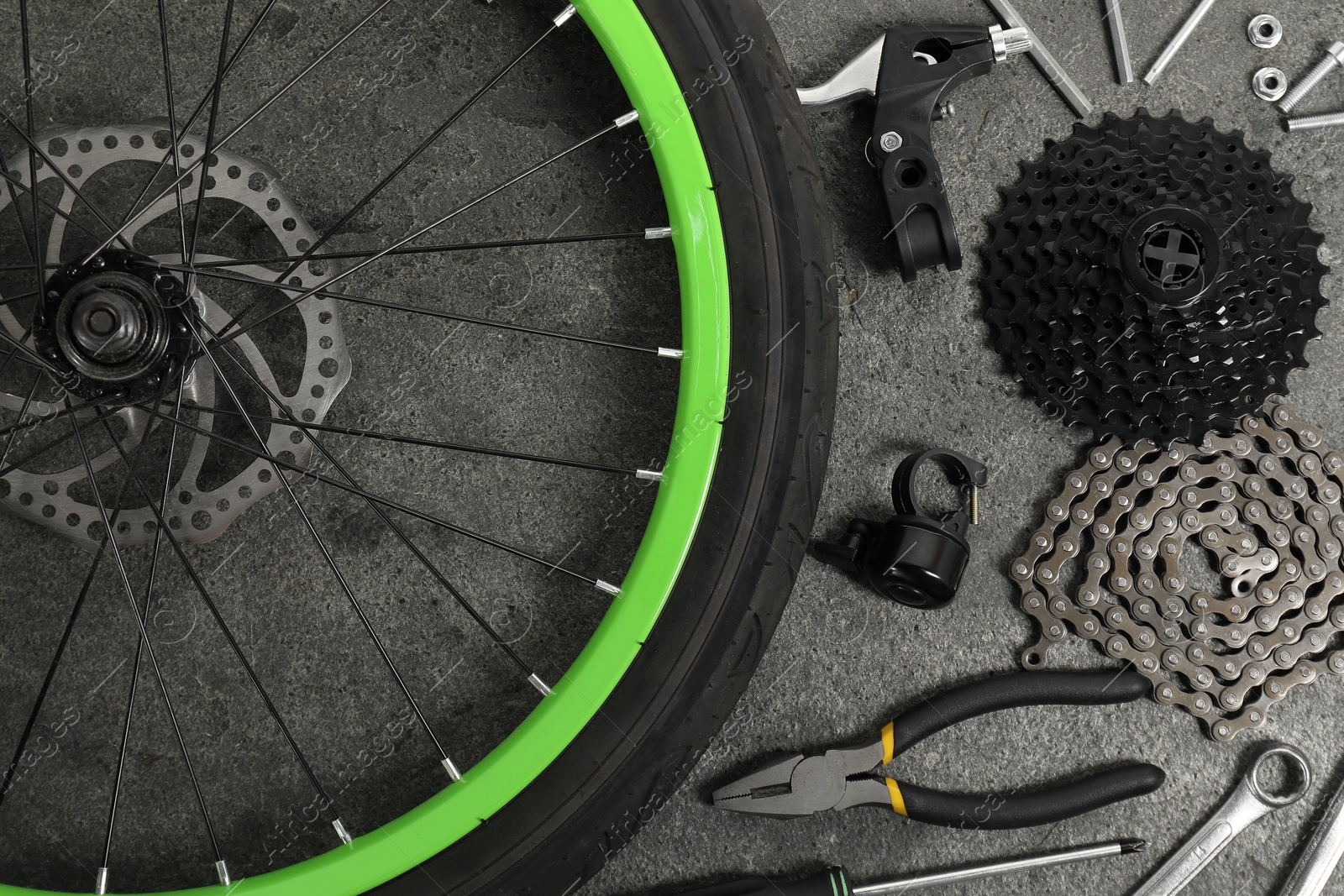 Photo of Parts of bicycle and tools on grey background, flat lay