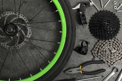 Parts of bicycle and tools on grey background, flat lay