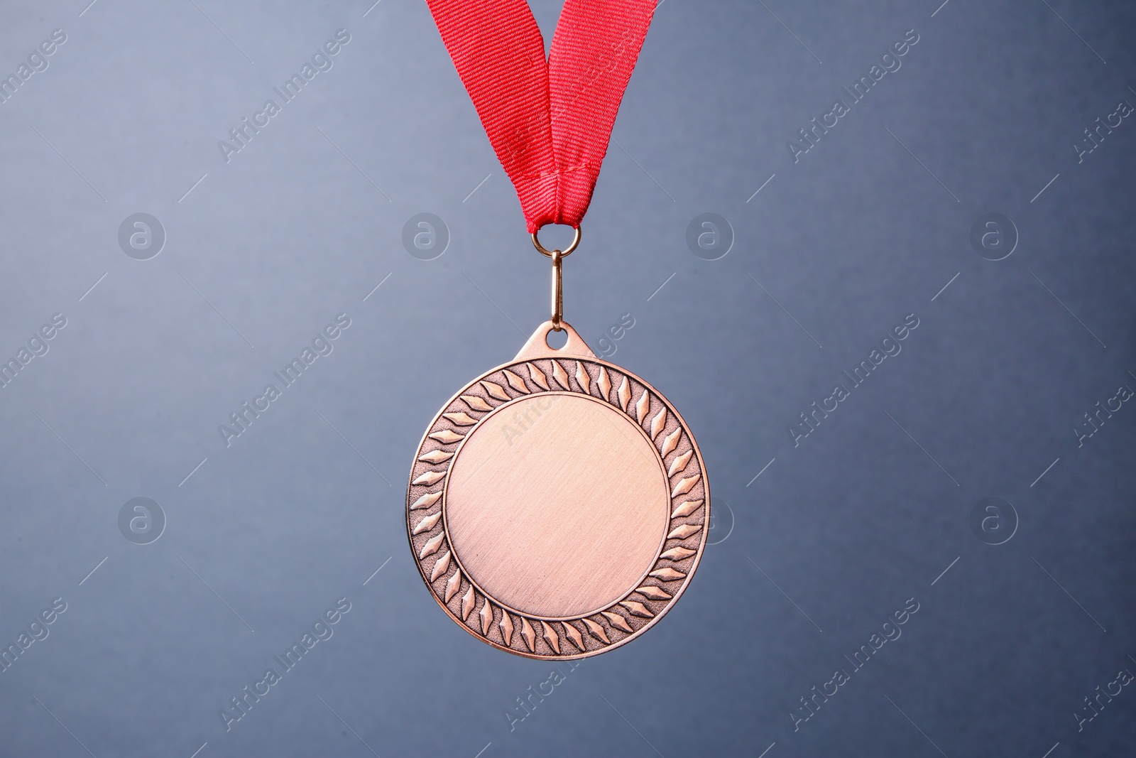 Photo of One bronze medal with ribbon on grey background