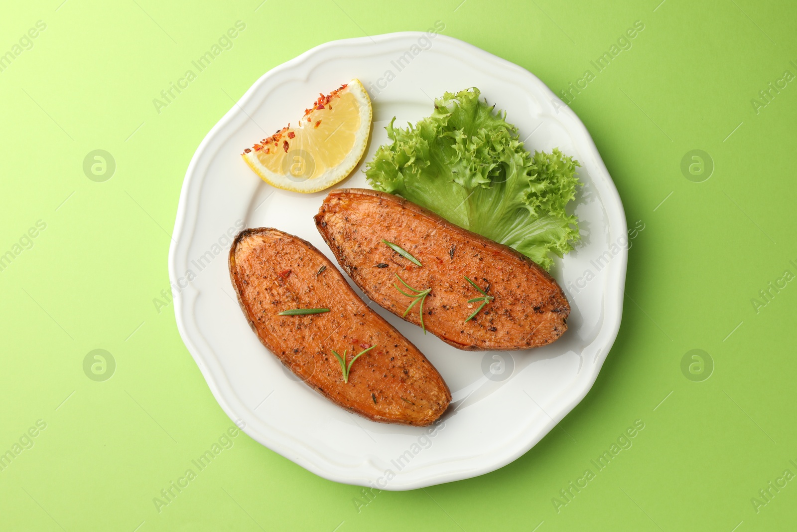 Photo of Tasty baked sweet potato served on green table, top view