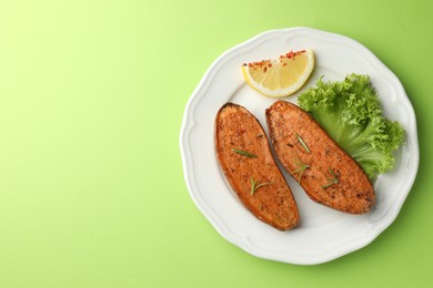 Photo of Tasty baked sweet potato served on green table, top view. Space for text